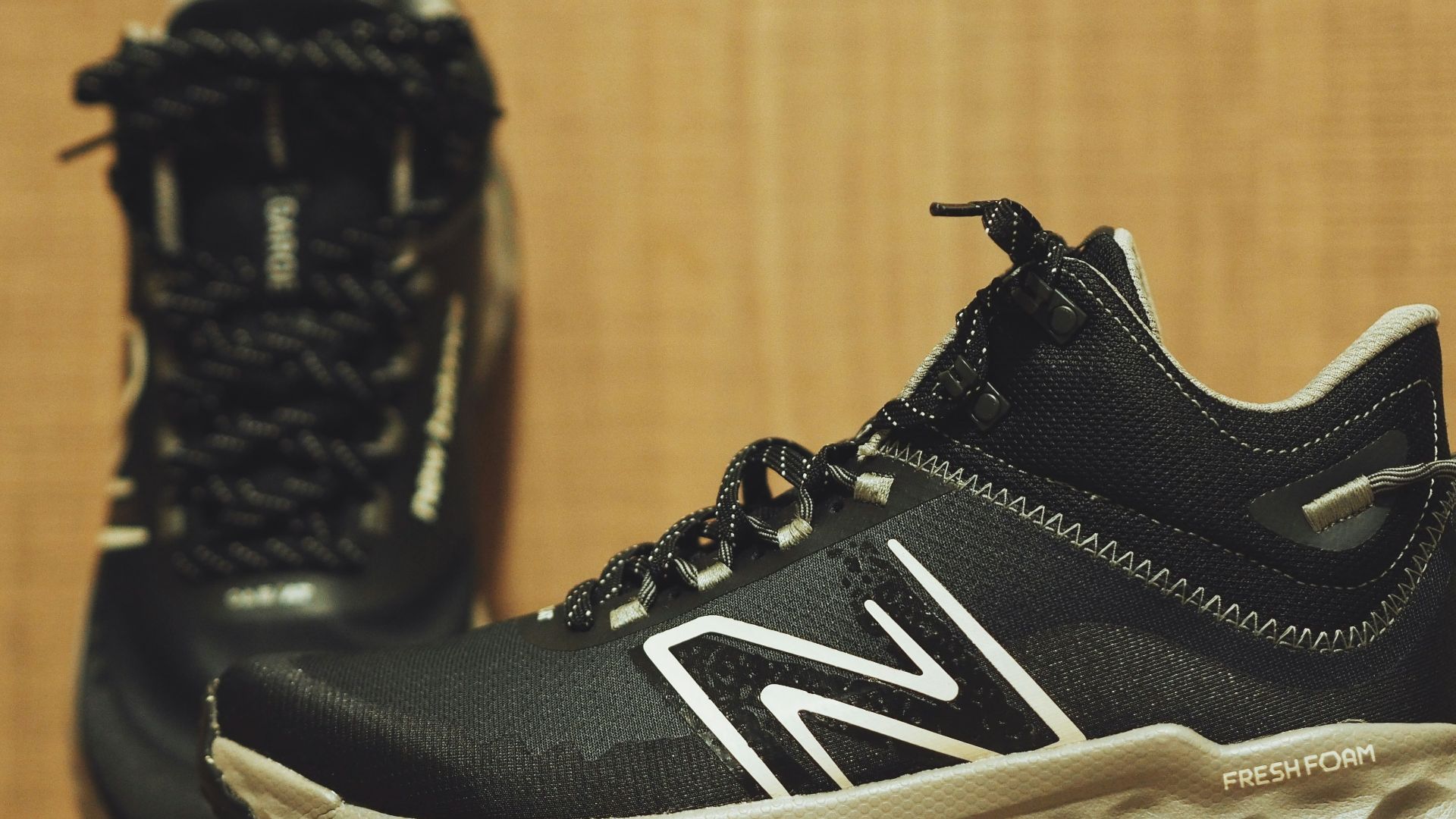 A pair of new balance shoes on a wooden floor