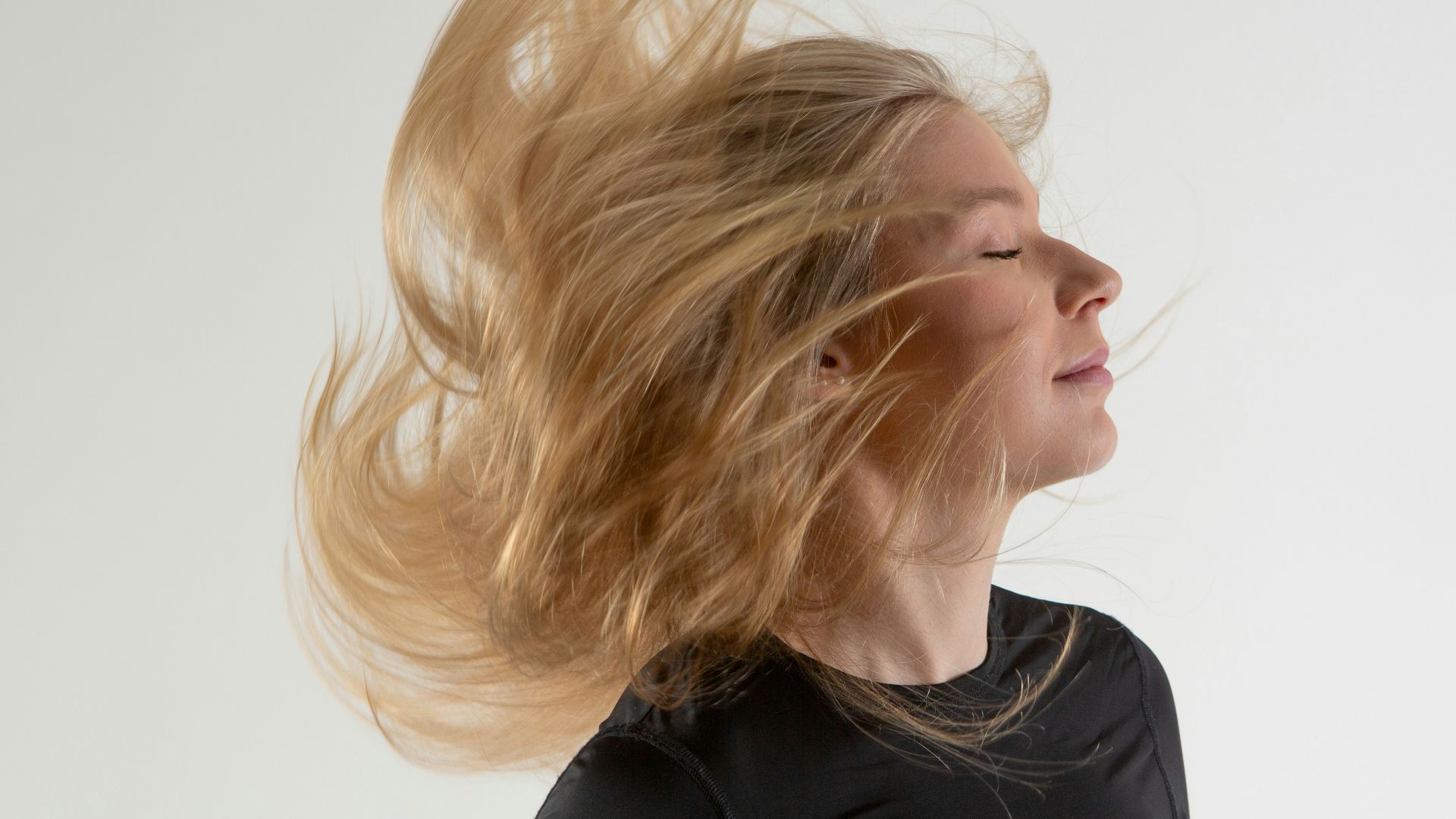 a woman with her hair blowing in the wind