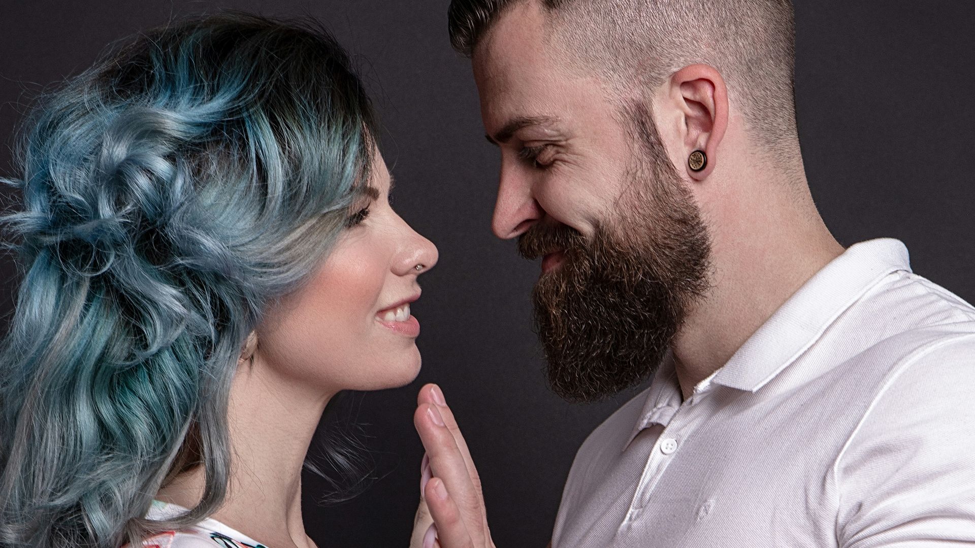 man in white crew neck t-shirt holding woman in white and red floral dress