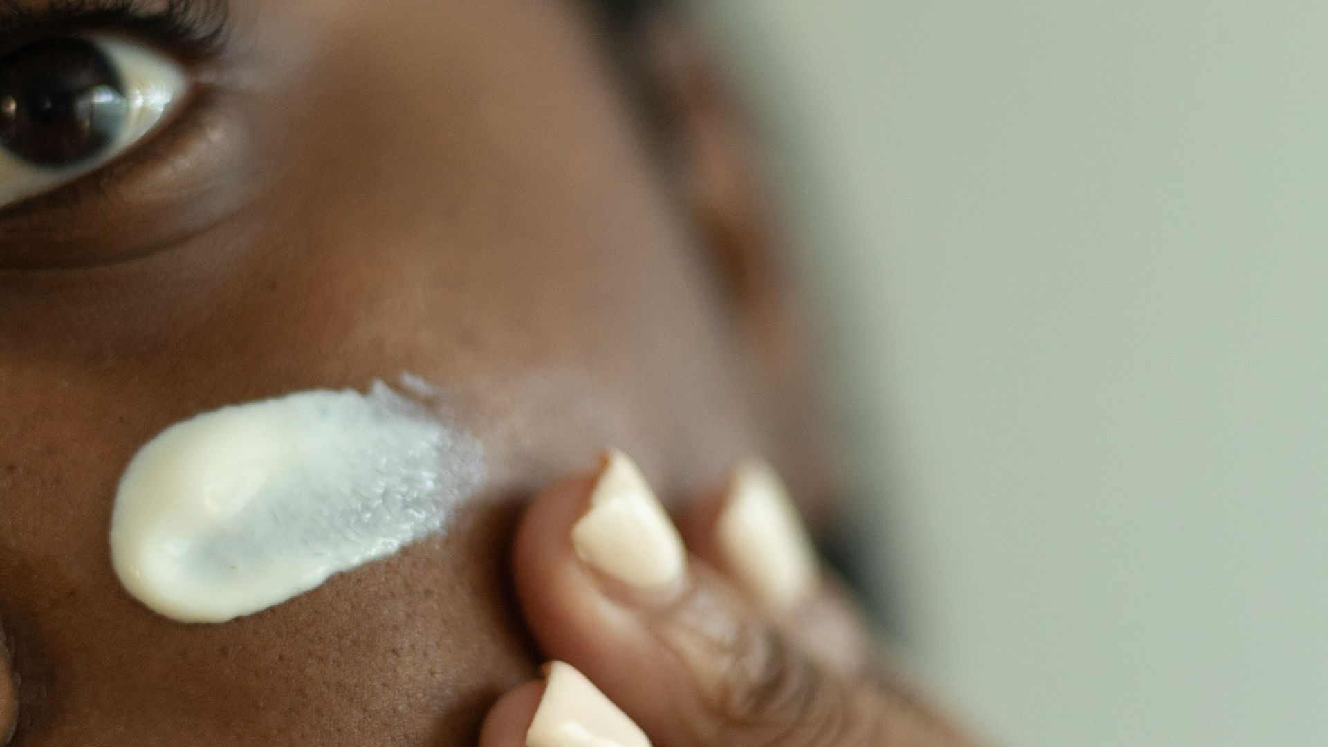 a woman putting cream on her face