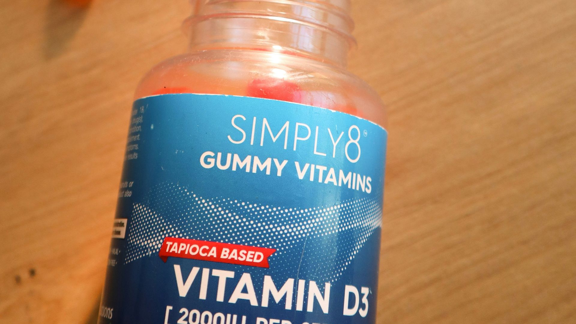 a bottle of gummy vitamins sitting on top of a wooden table