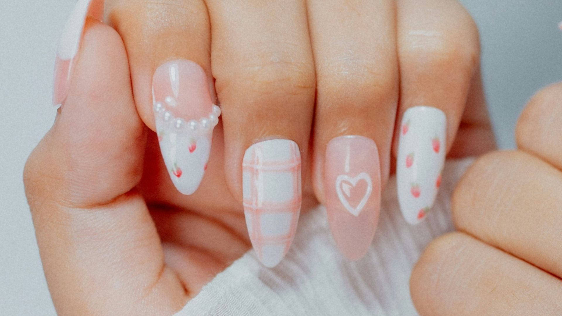 Woman's hands with white and pink heart-designed nails