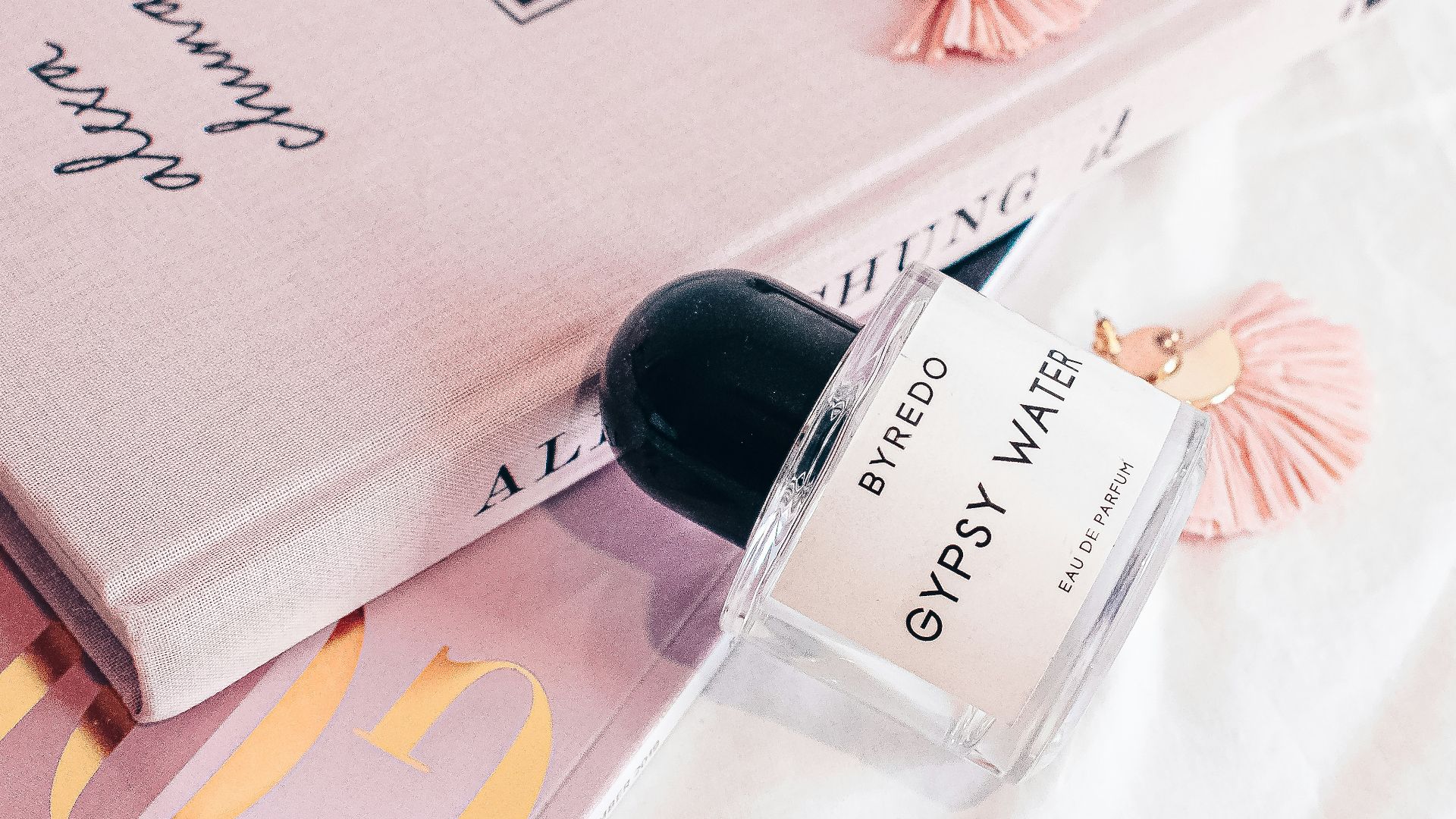 a bottle of perfume sitting on top of a book