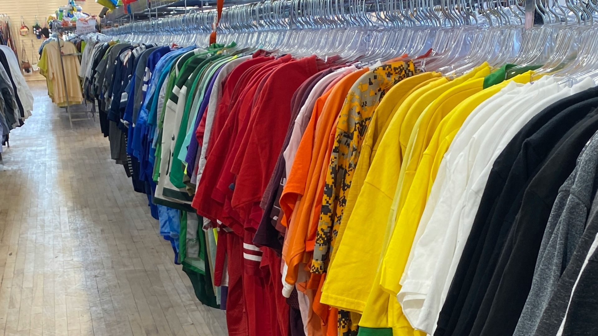 a row of shirts hanging on a rack in a store