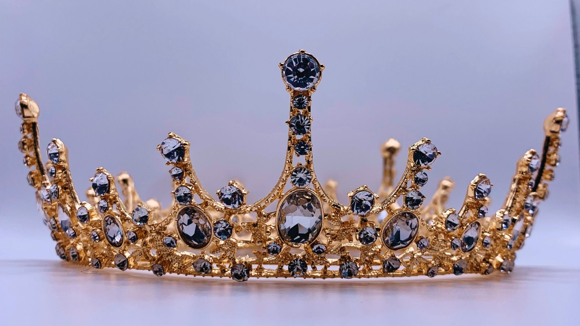 a gold crown with black and white stones