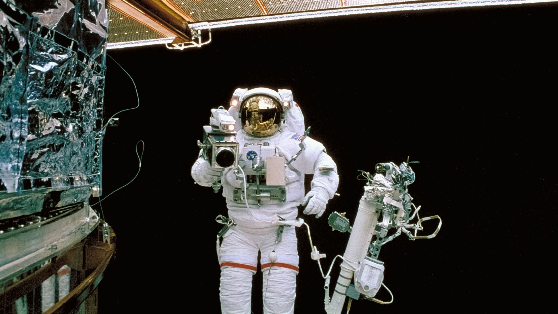 a man in a space suit standing next to a space station