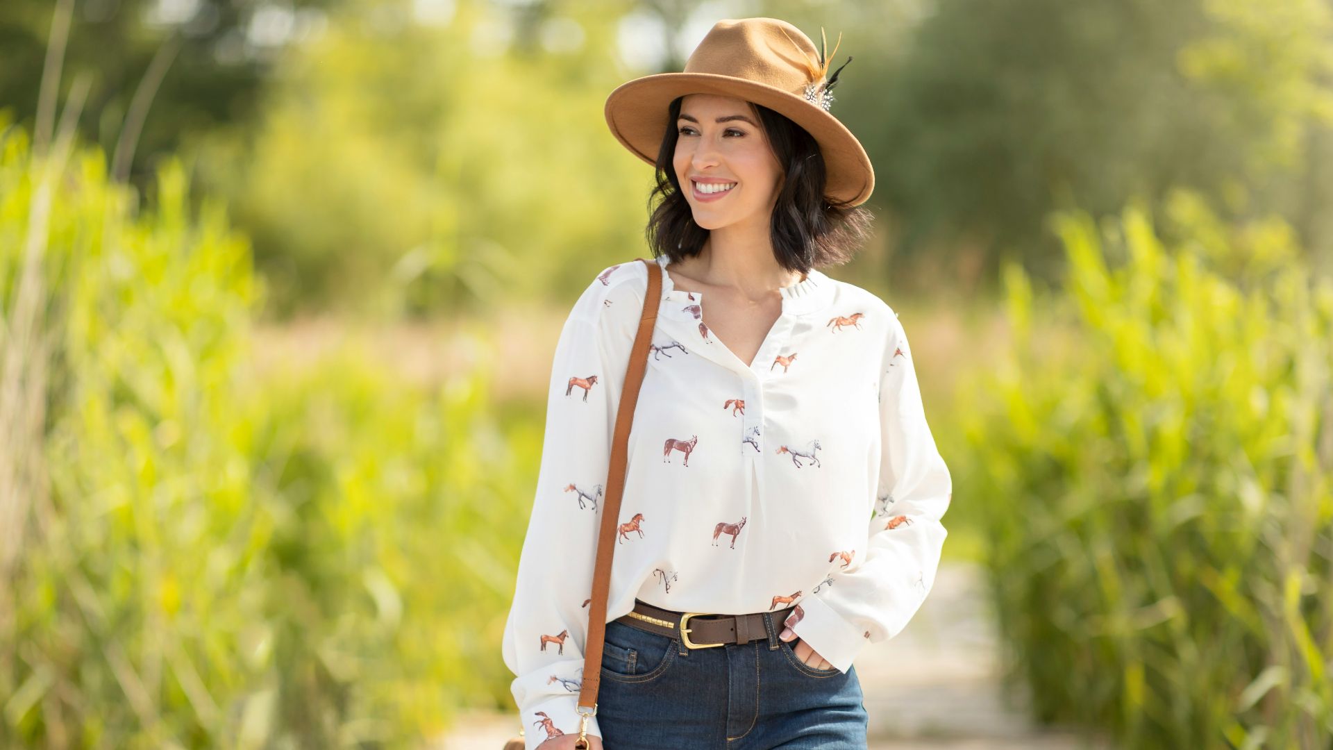 A woman in a hat is walking down a path