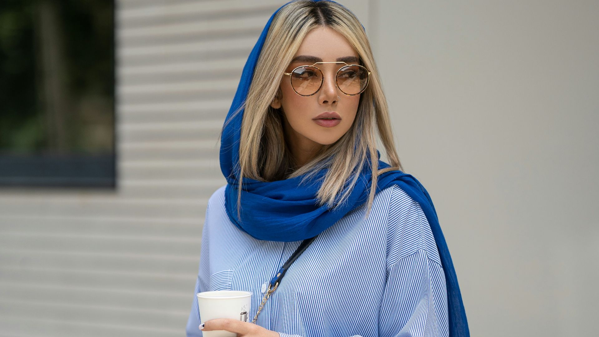 a woman wearing glasses and a blue sweater