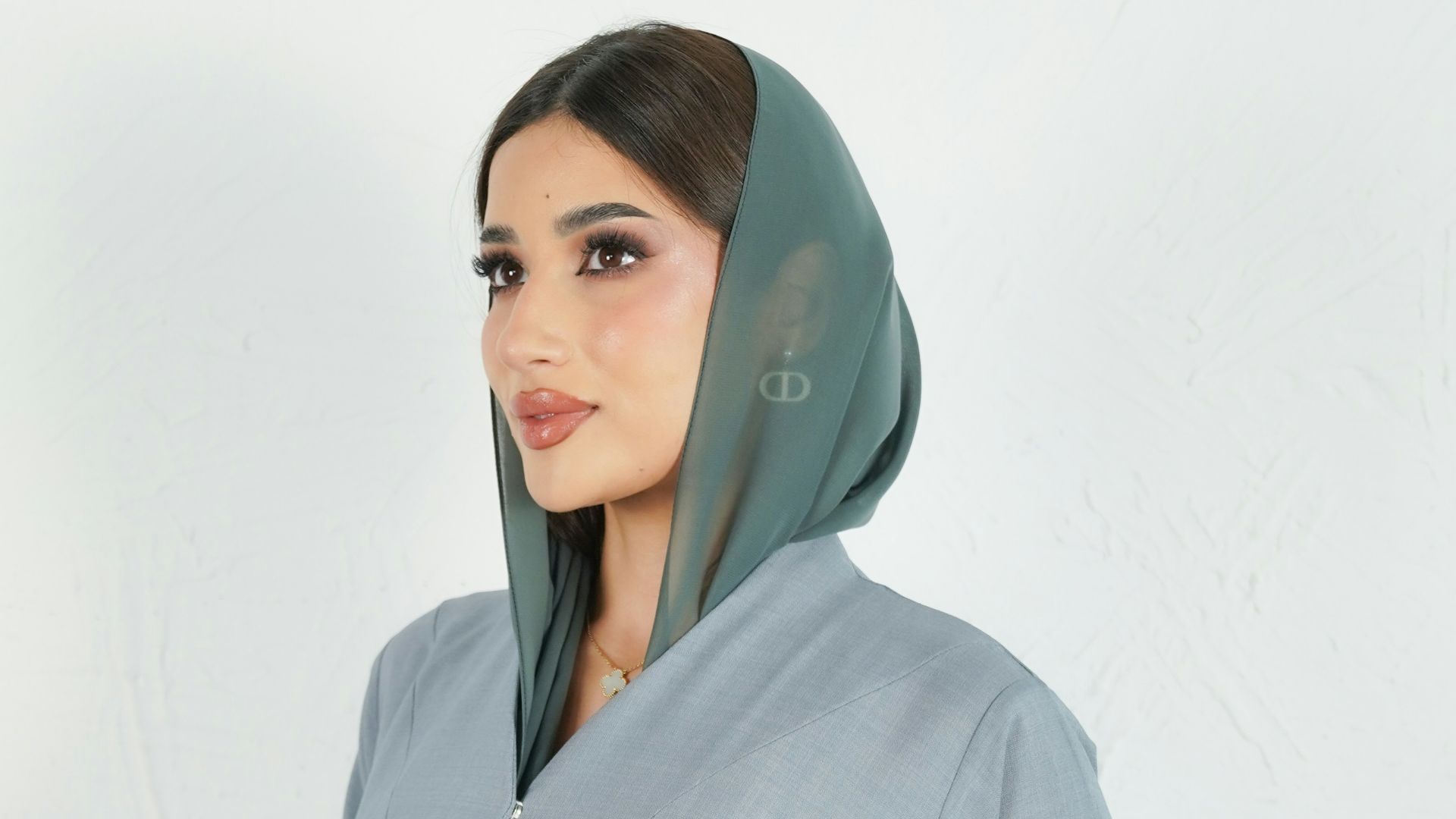 Woman wears a beautiful gray abaya with a headscarf.