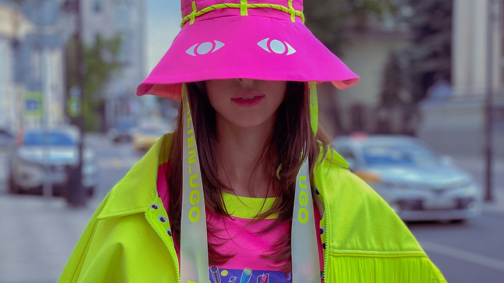 woman in green jacket wearing pink hat
