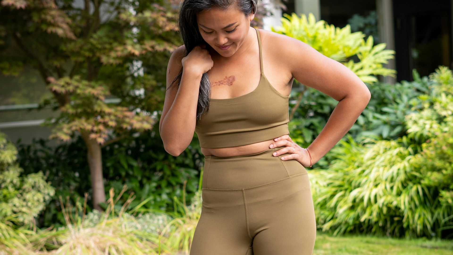 woman in brown bra and brown pants standing on gray concrete pathway during daytime