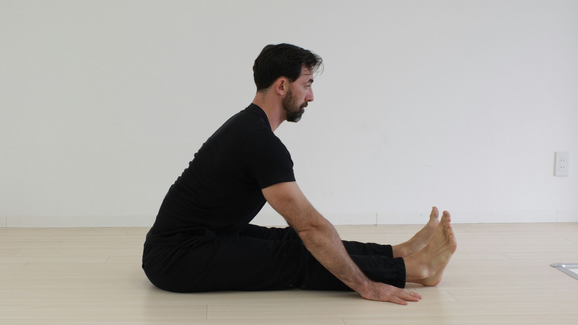 a man sitting on the floor in a white room