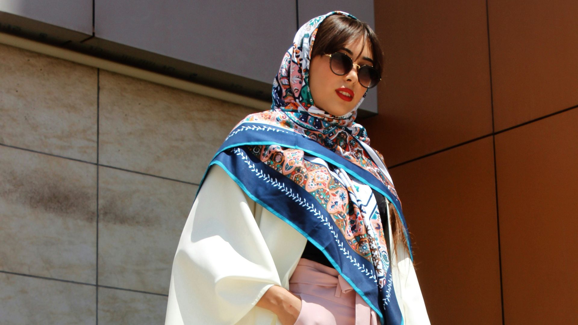 woman wearing pink pants holding grey leather handbag