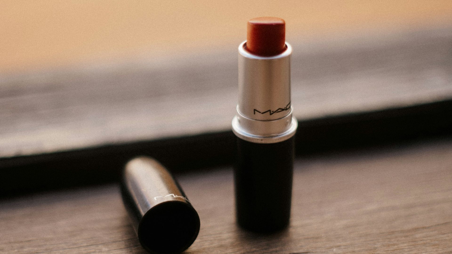 red lipstick on brown wooden table