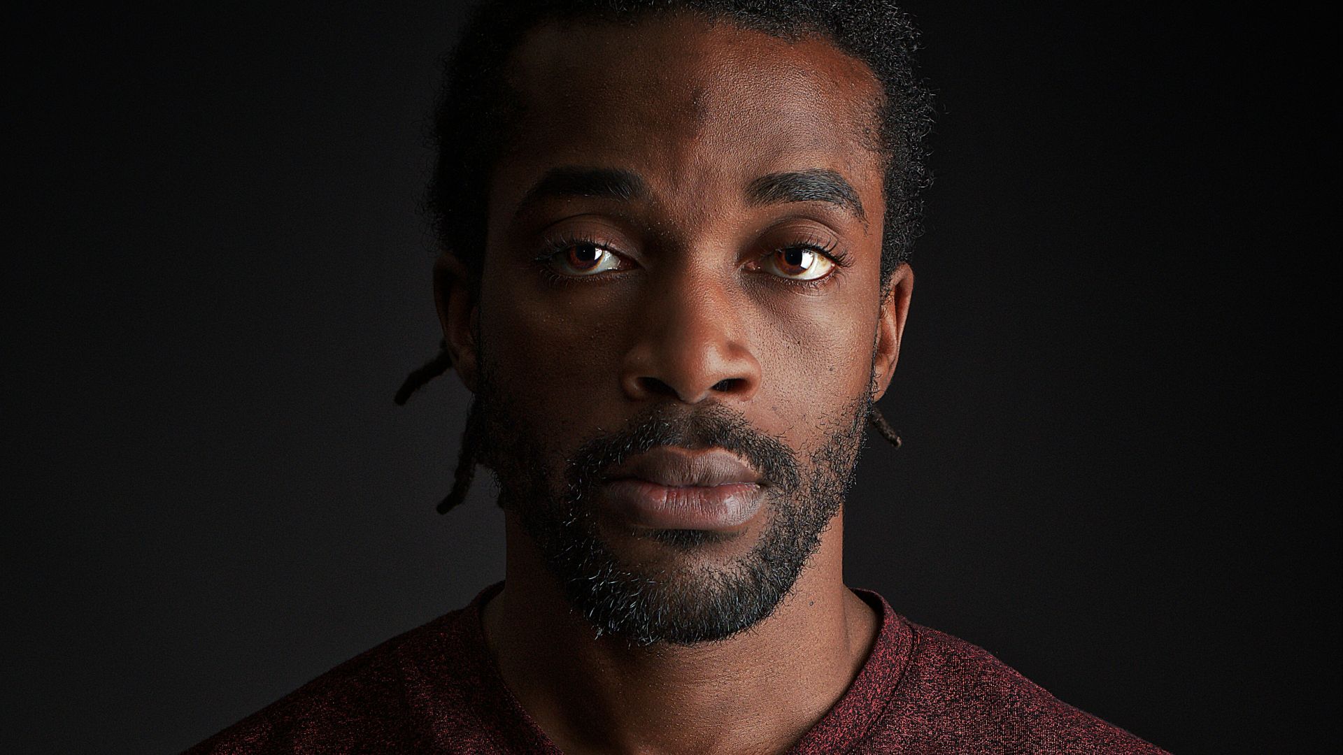 man wearing red v-neck shirt close-up photography