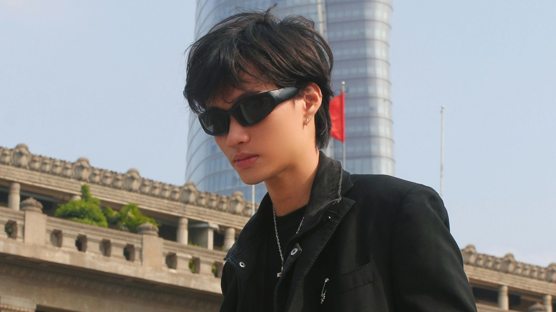 a man standing in front of a tall building