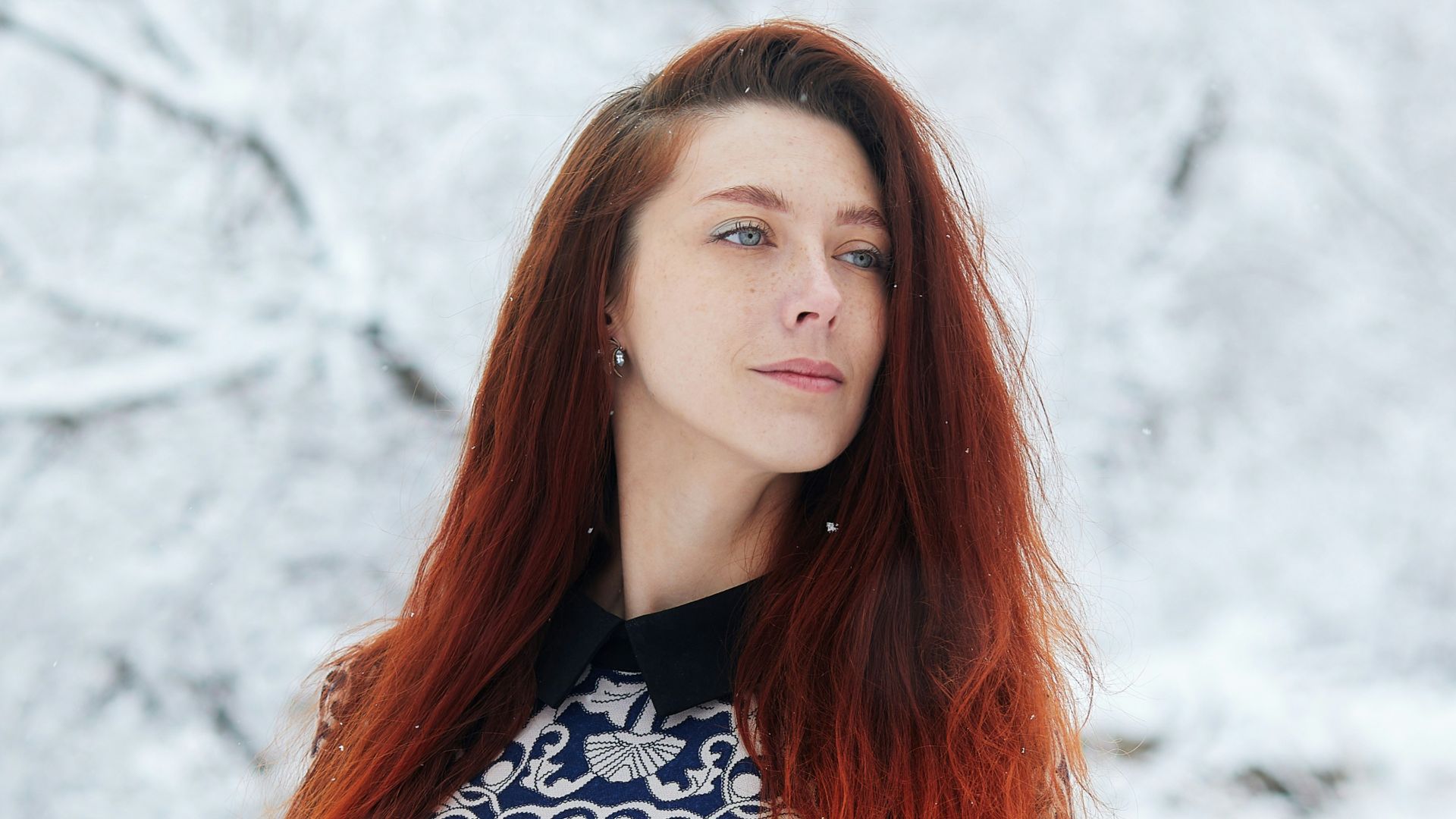 woman in black and white long sleeve dress standing on snow covered ground during daytime
