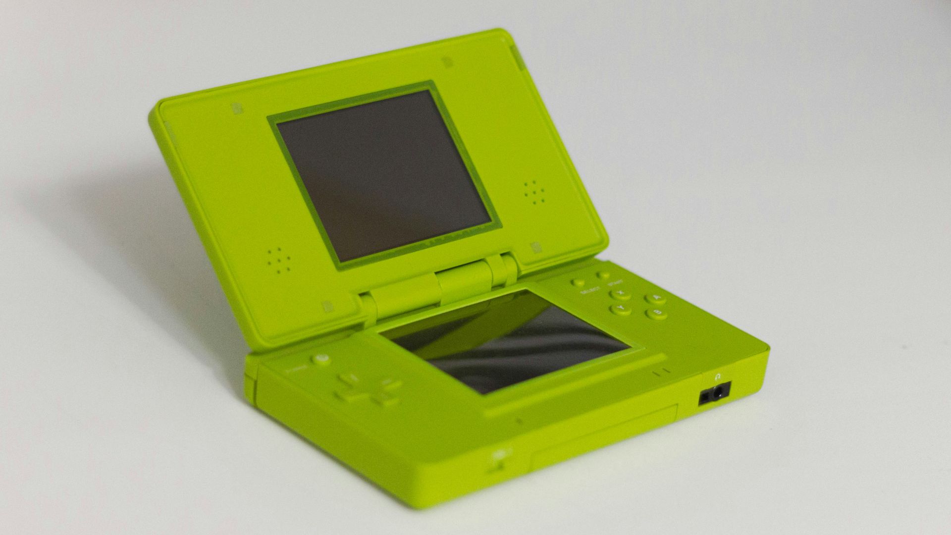 A lime green nintendo ds is displayed open.