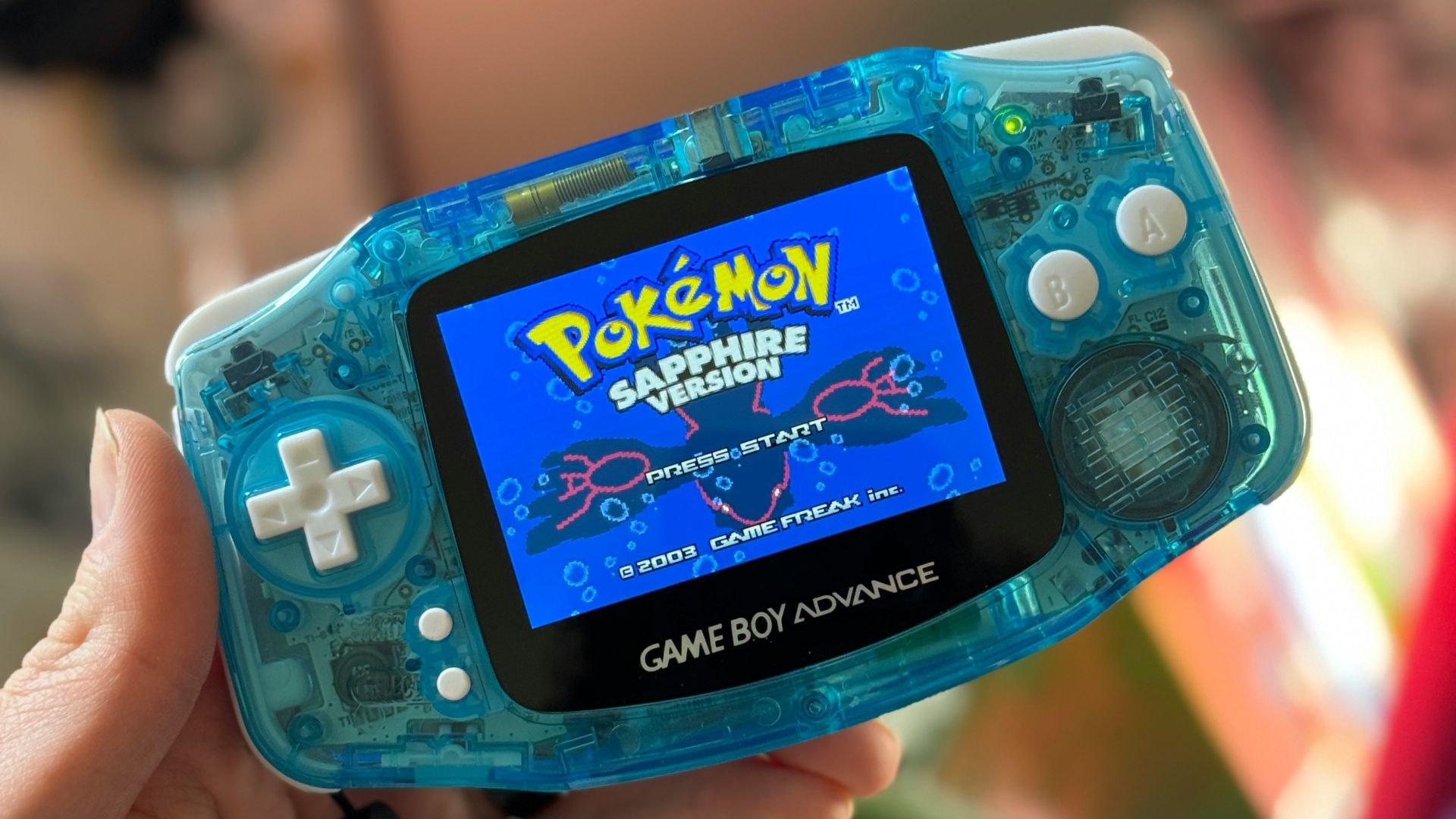 a person holding a gameboy in their hand