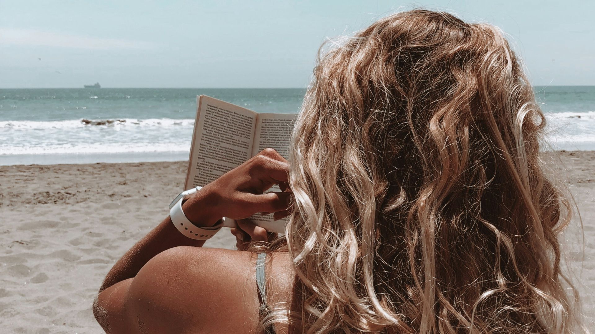 woman in brown bikini holding book
