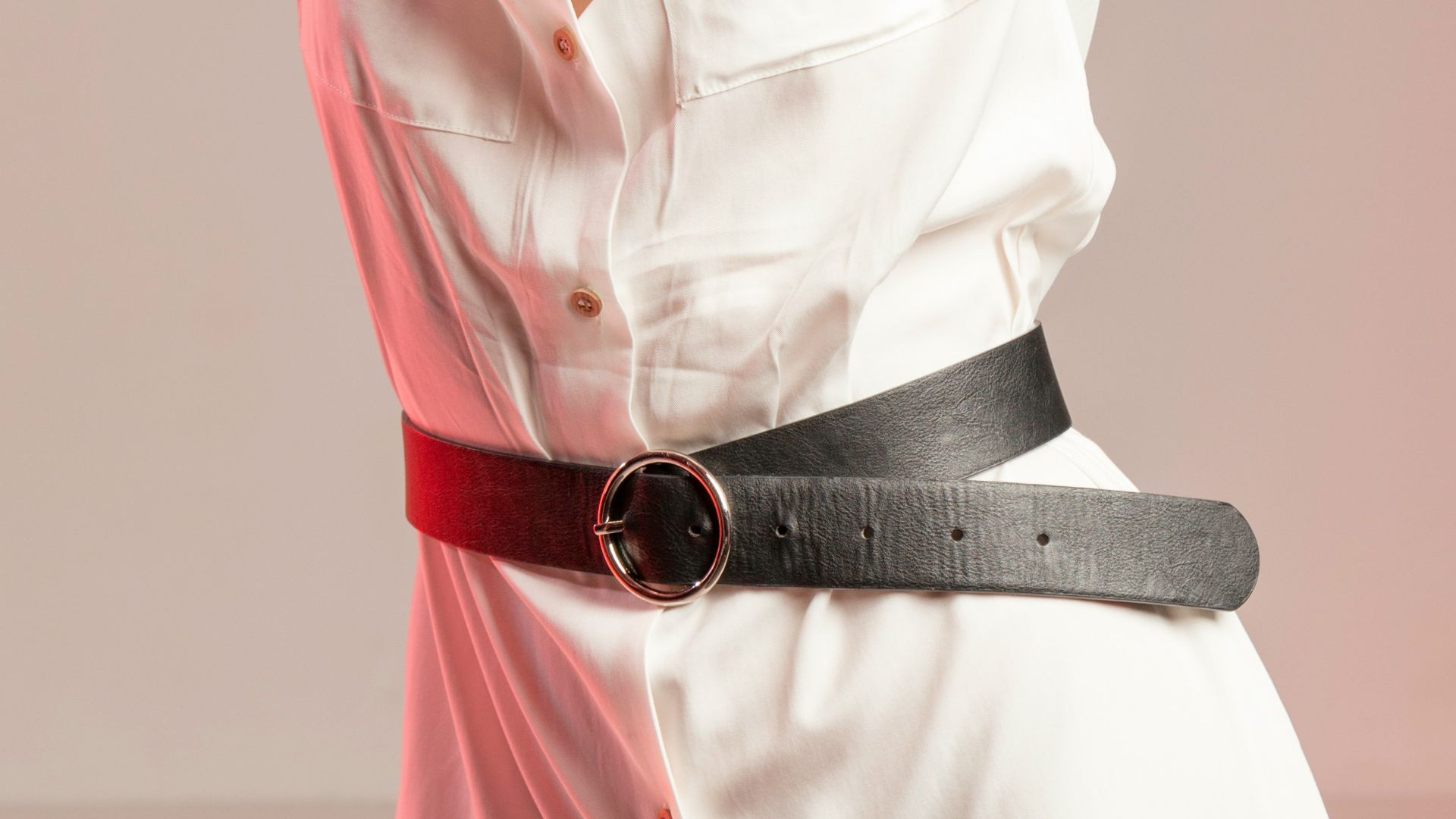 woman wearing white collared button-up dress standing while putting both hands on her head