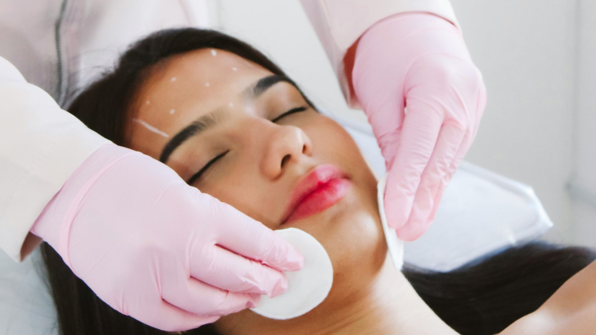 A woman getting a facial mask on her face