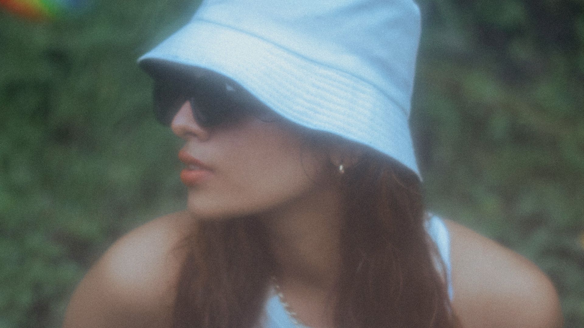 a woman wearing a white hat and sunglasses