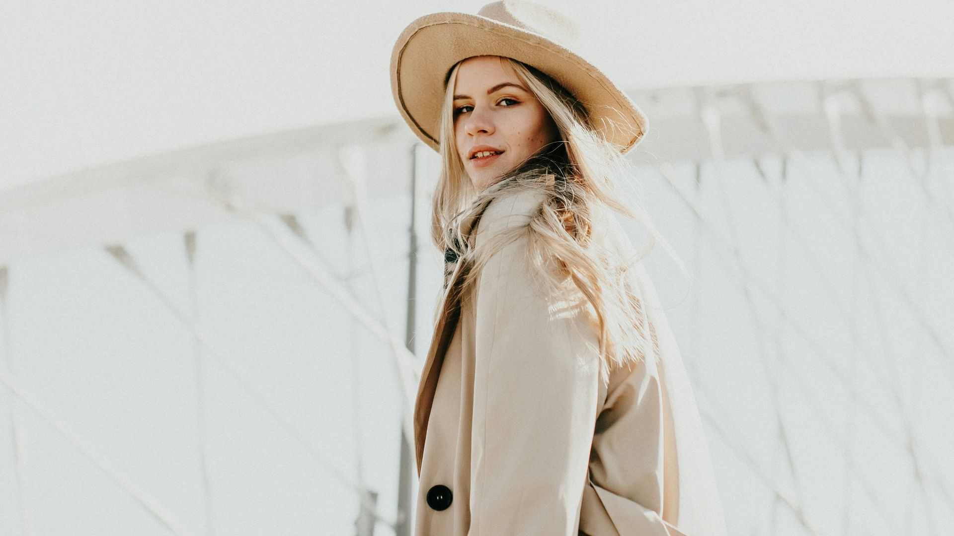 woman in brown coat wearing brown hat standing on snow covered ground during daytime