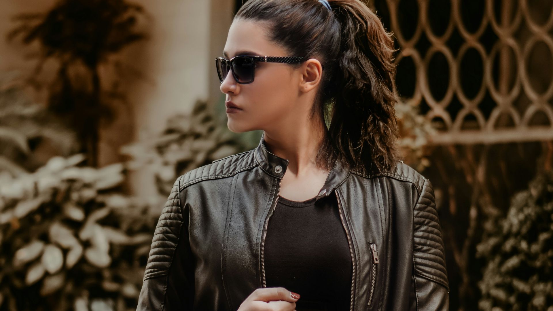woman in black leather jacket wearing black sunglasses