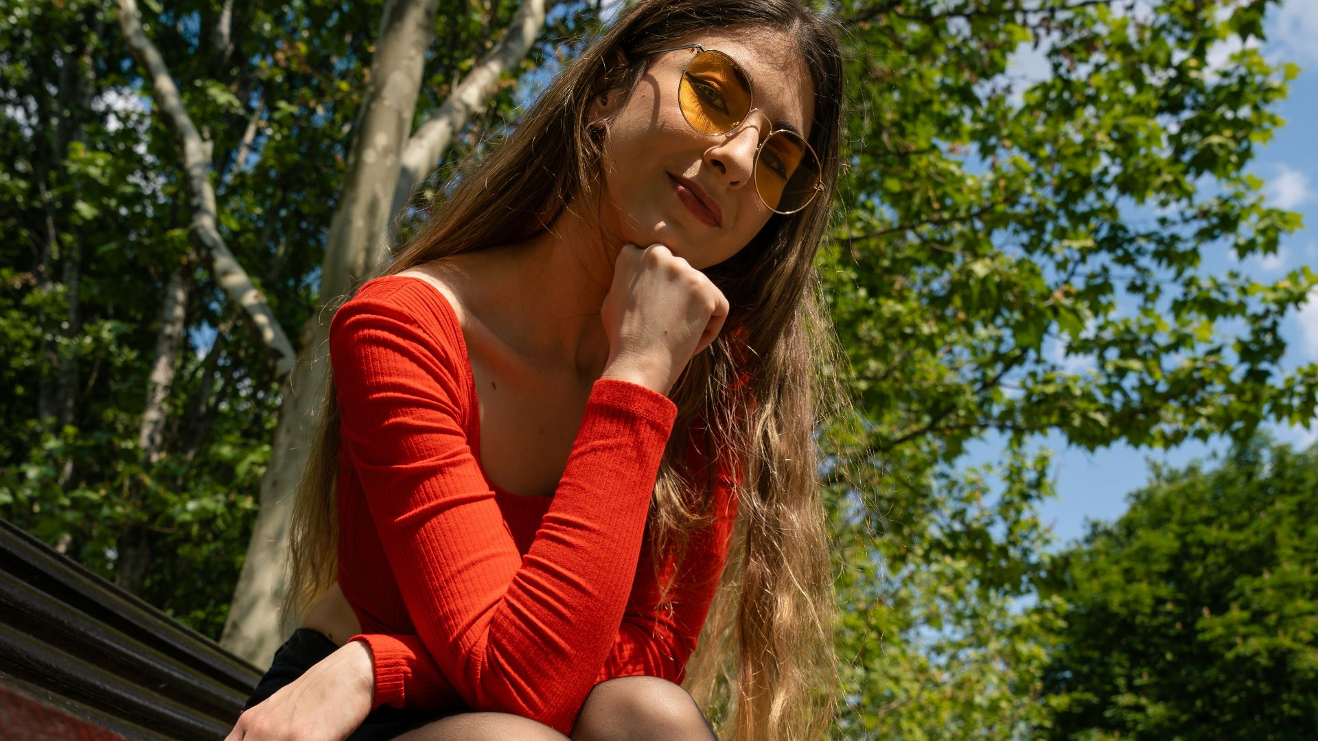 a woman sitting on a bench in a park