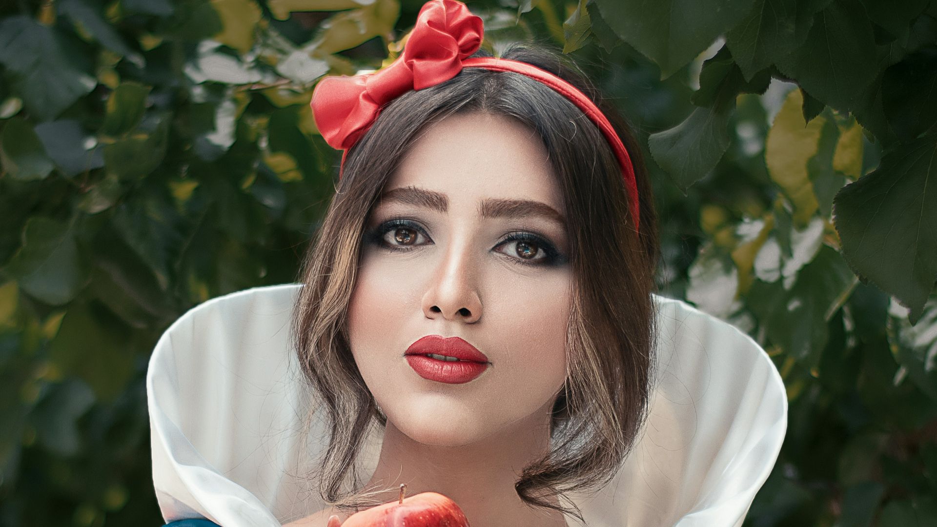 woman in red and white crew neck t-shirt holding red apple fruit