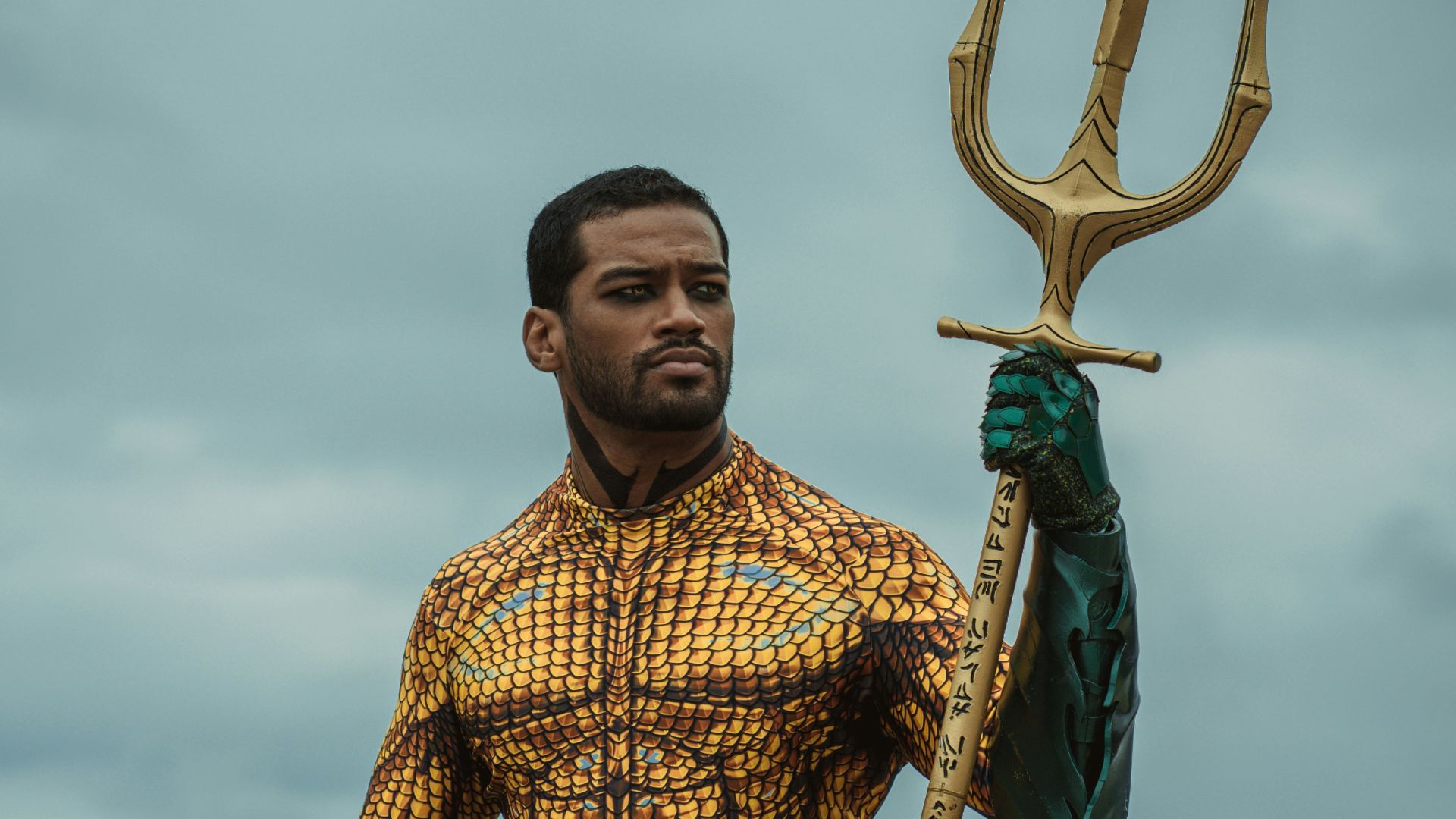 a man dressed as a mermaid holding a spear