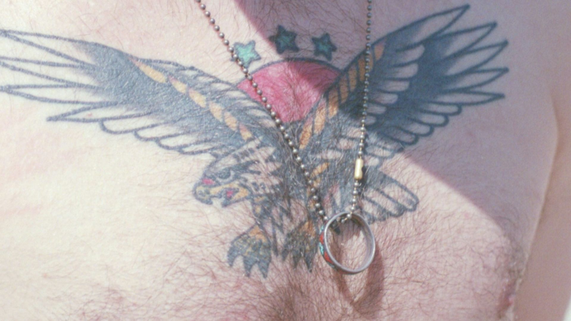 a man with a bird tattoo on his chest
