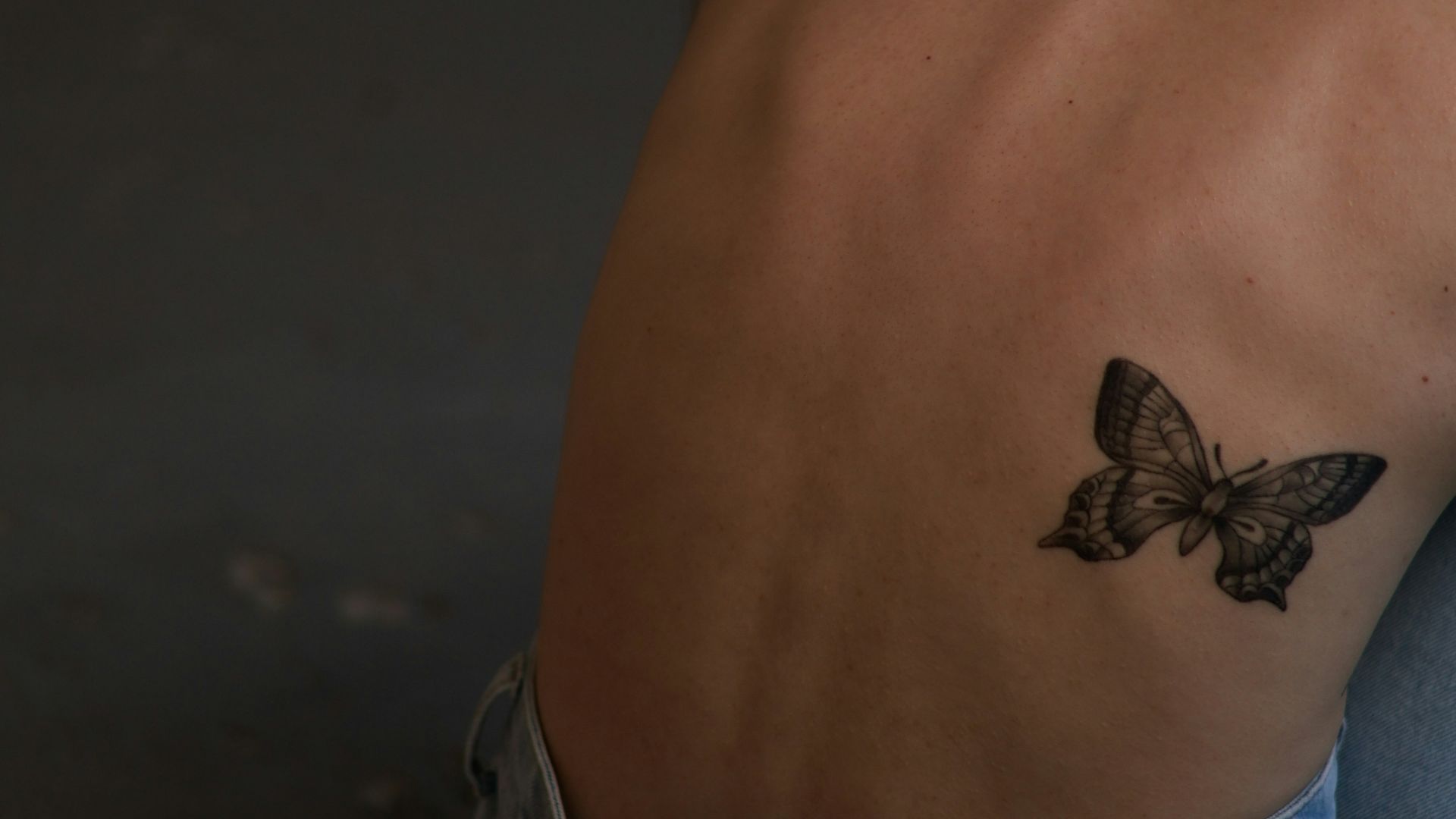 a woman with a butterfly tattoo on her back