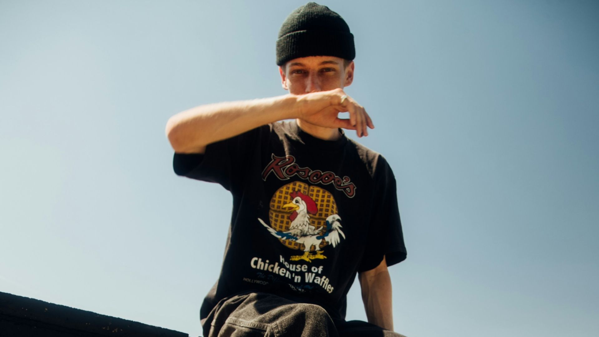 man in black t-shirt and black pants sitting on black concrete bench during daytime