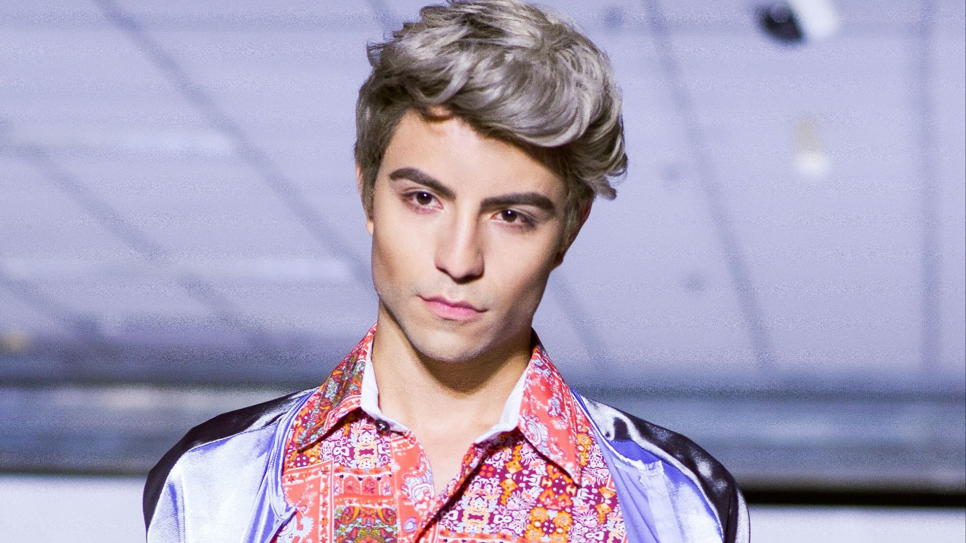 man in blue denim jacket holding black sling bag