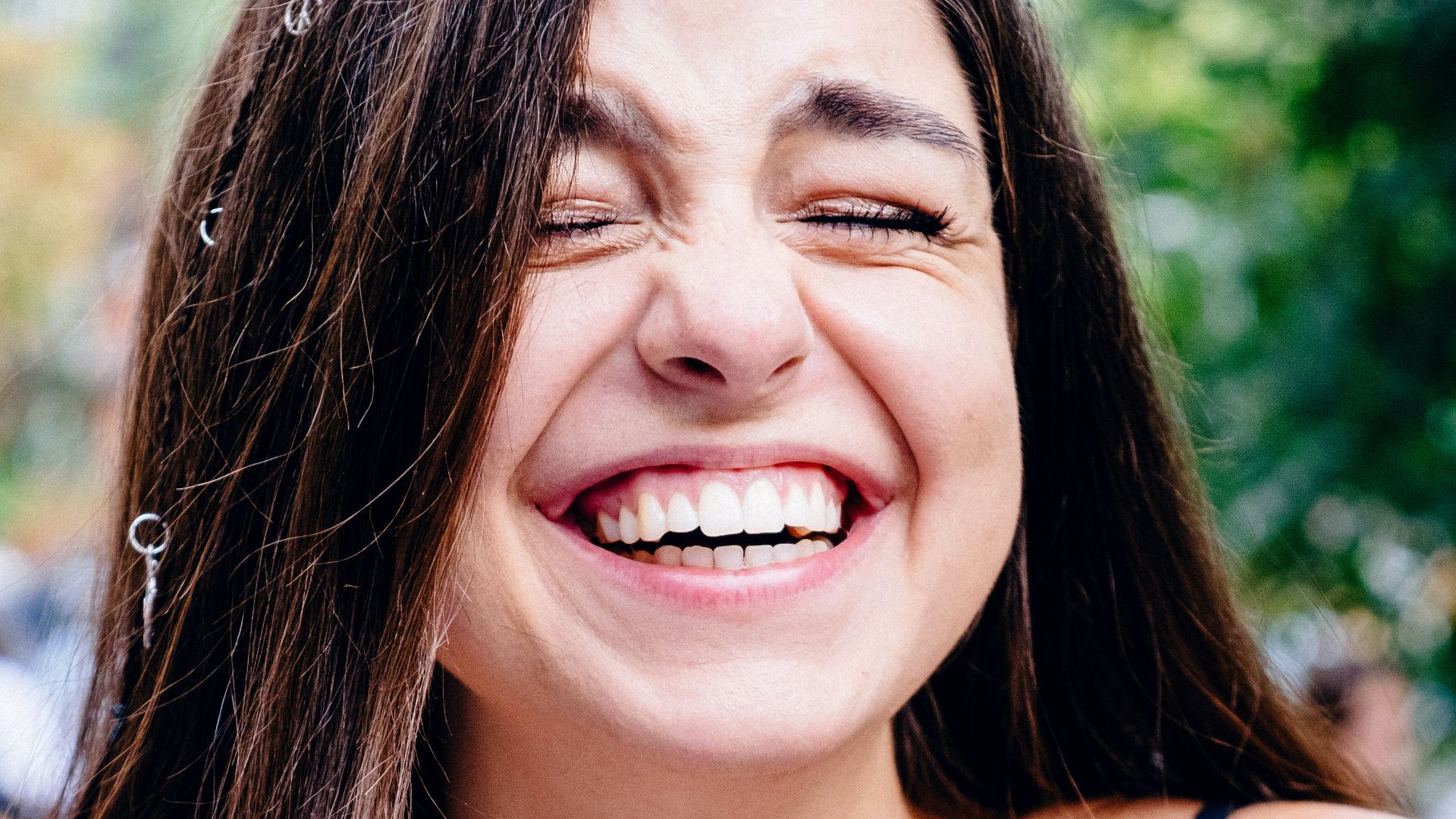 woman in black spaghetti strap top smiling
