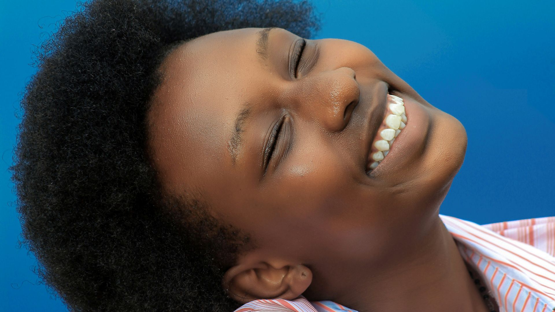 smiling girl in pink and white stripe shirt