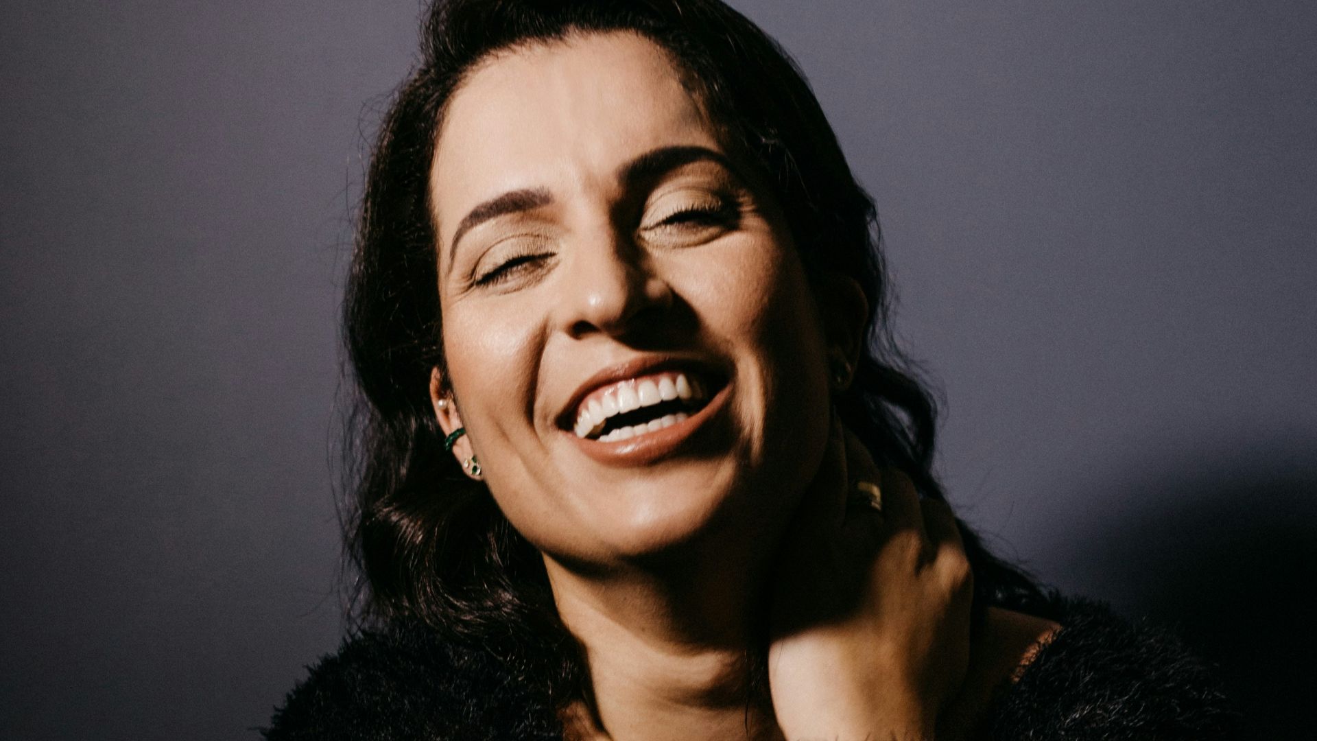 smiling woman in black fur coat