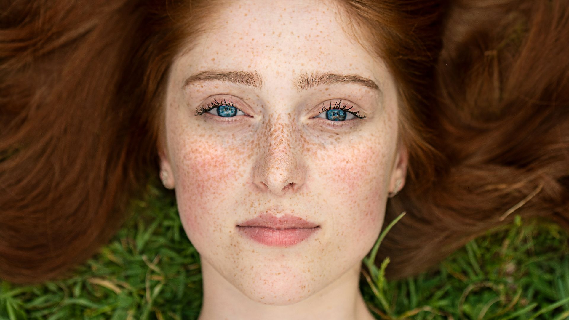 woman in green shirt lying on brown grass