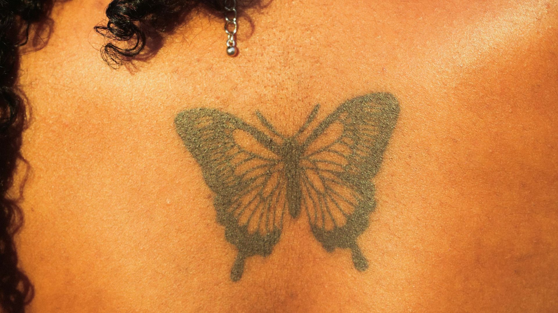 a woman with a butterfly tattoo on her back