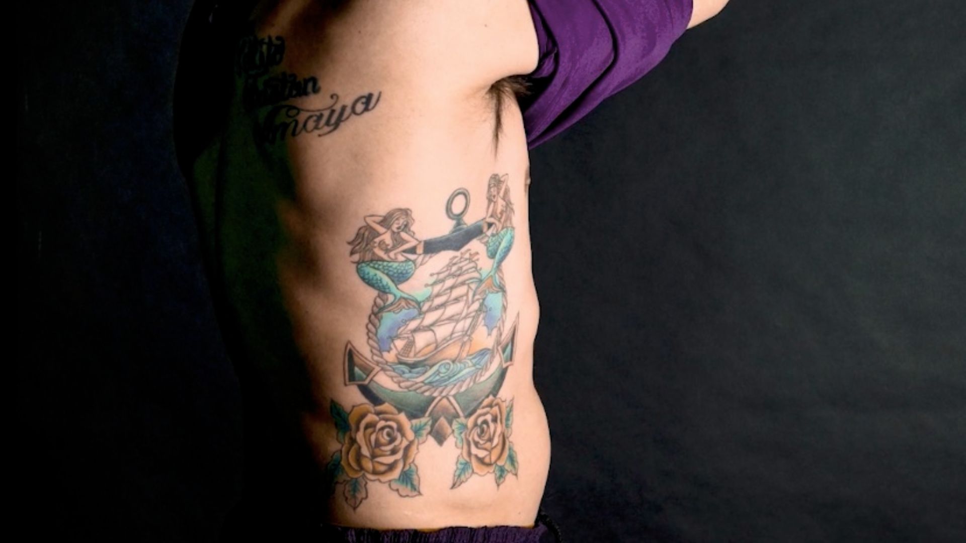 File:Man with tattoo of ship with roses and mermaids.jpg