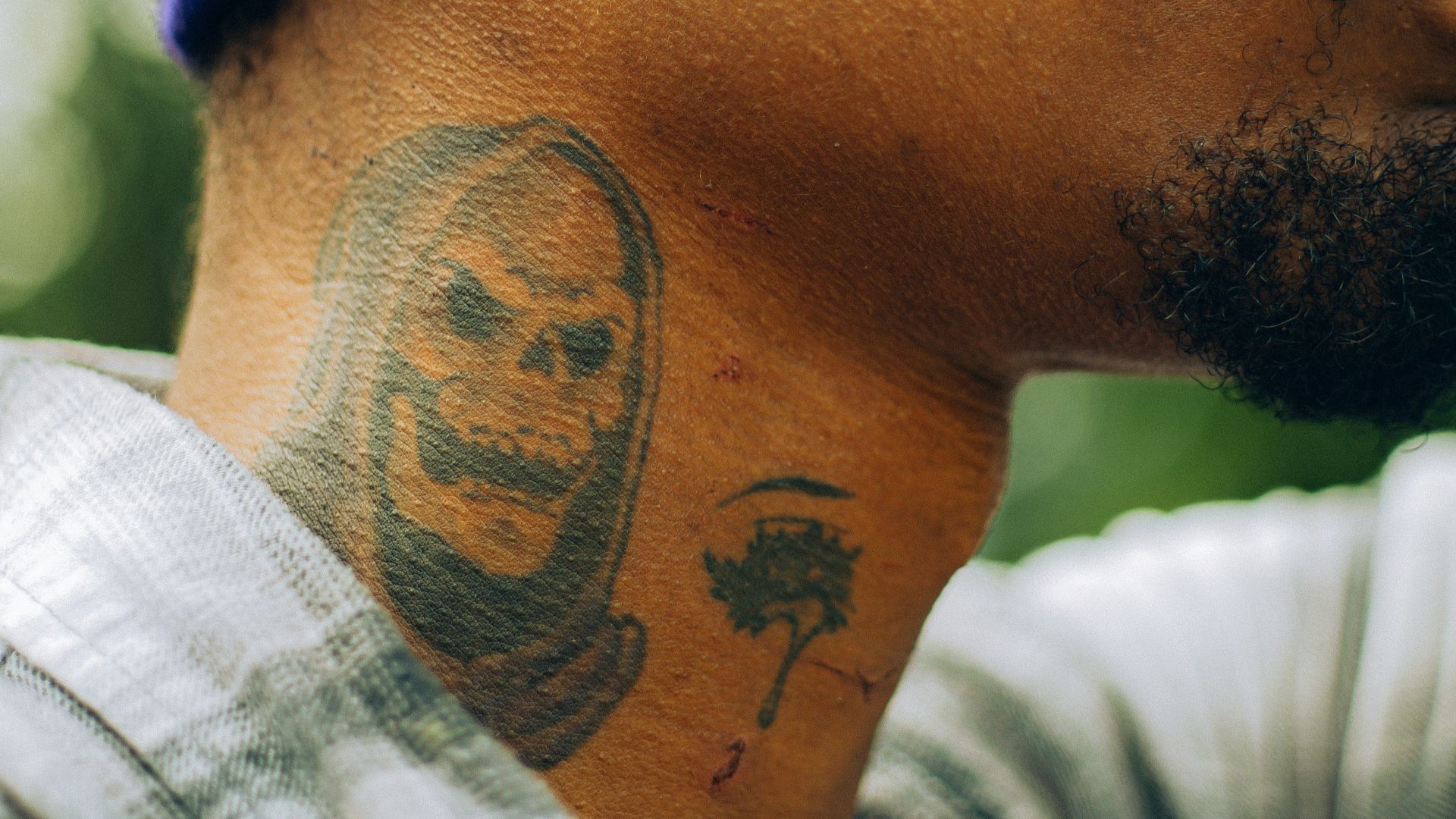 a man with a face tattoo on his neck