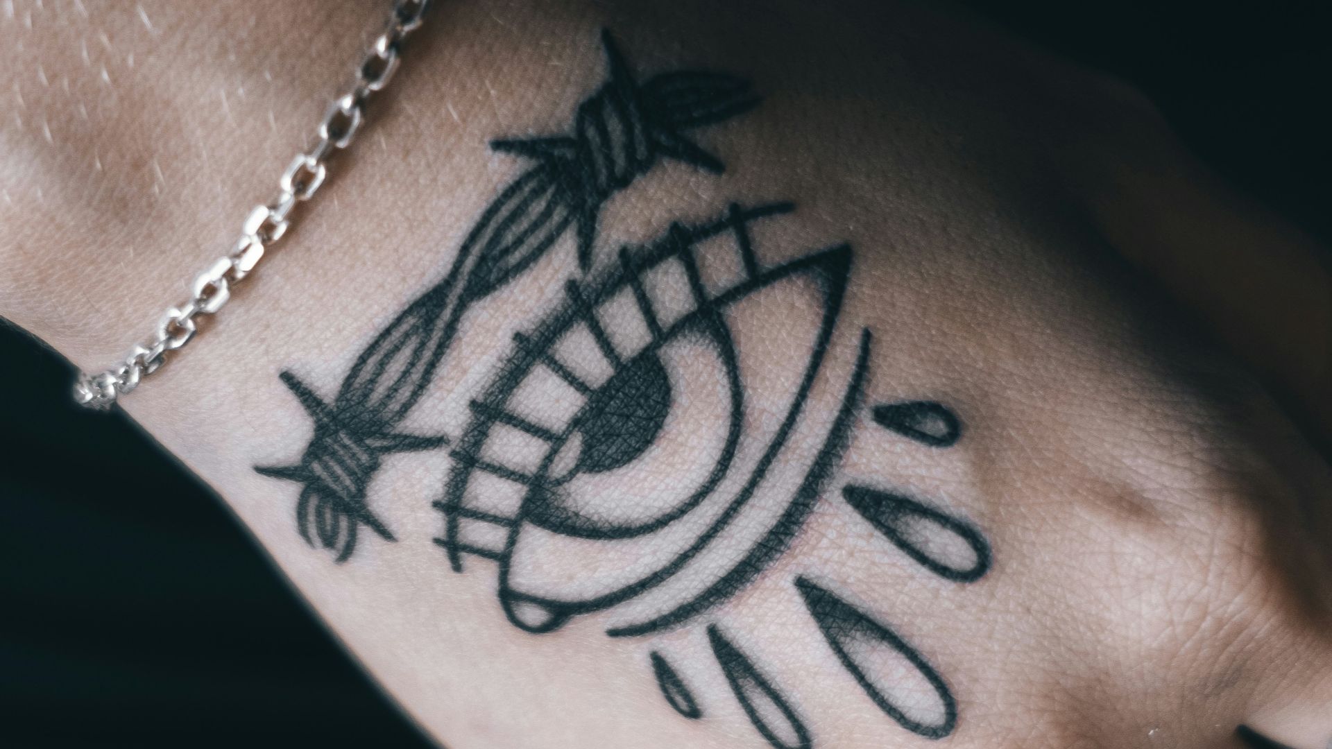 person with black tattoo on wrist