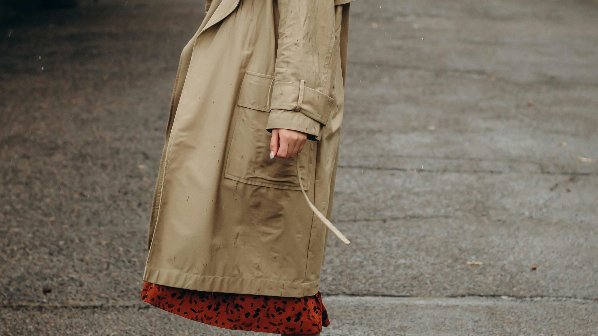 woman in brown coat holding umbrella walking on street during daytime