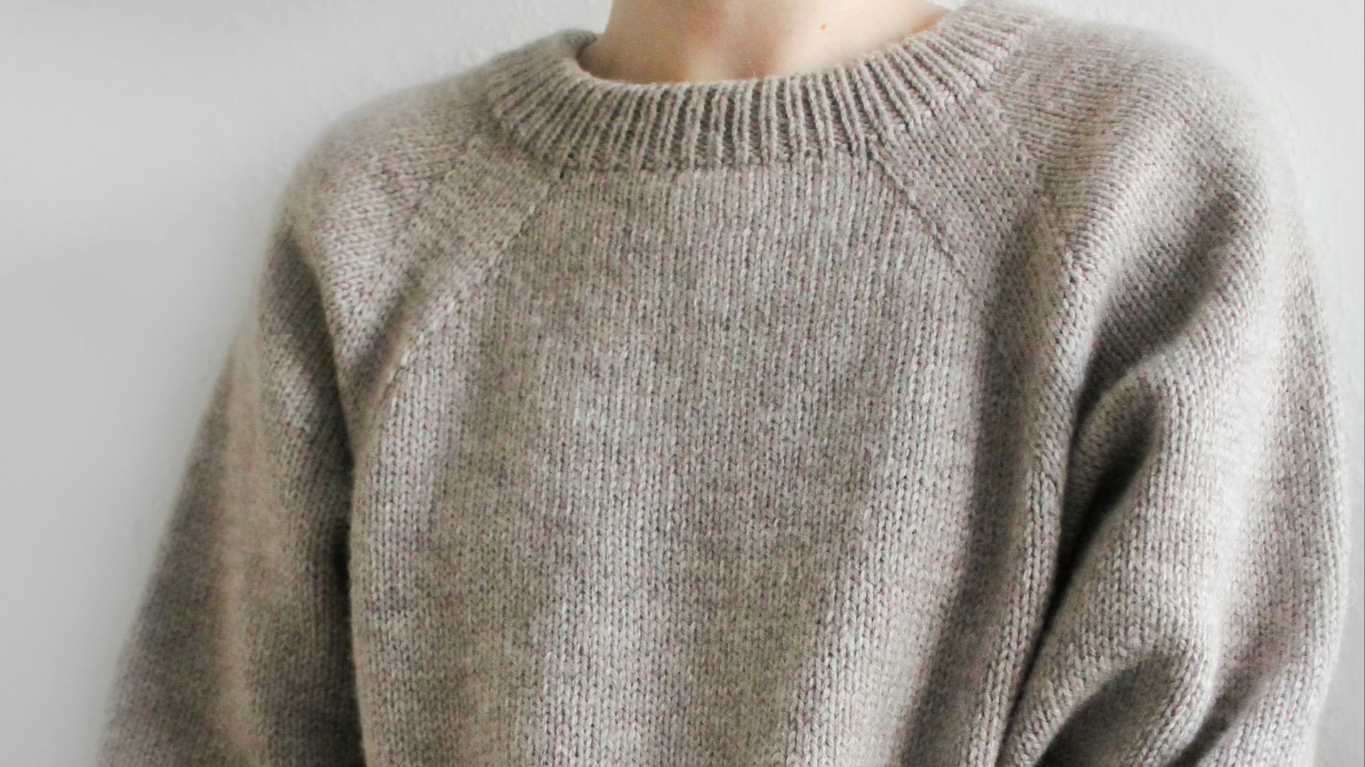 a person wearing a grey sweater