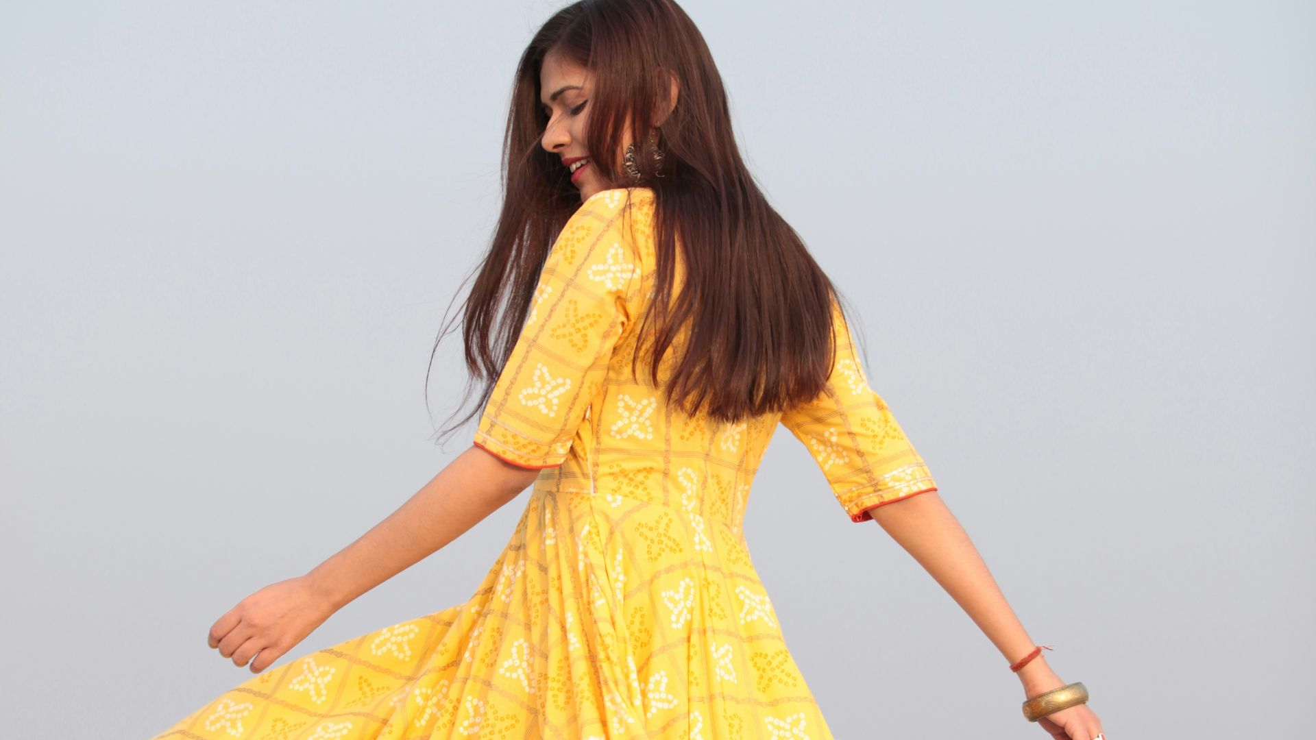 woman swishing her yellow long-sleeved maxi dress