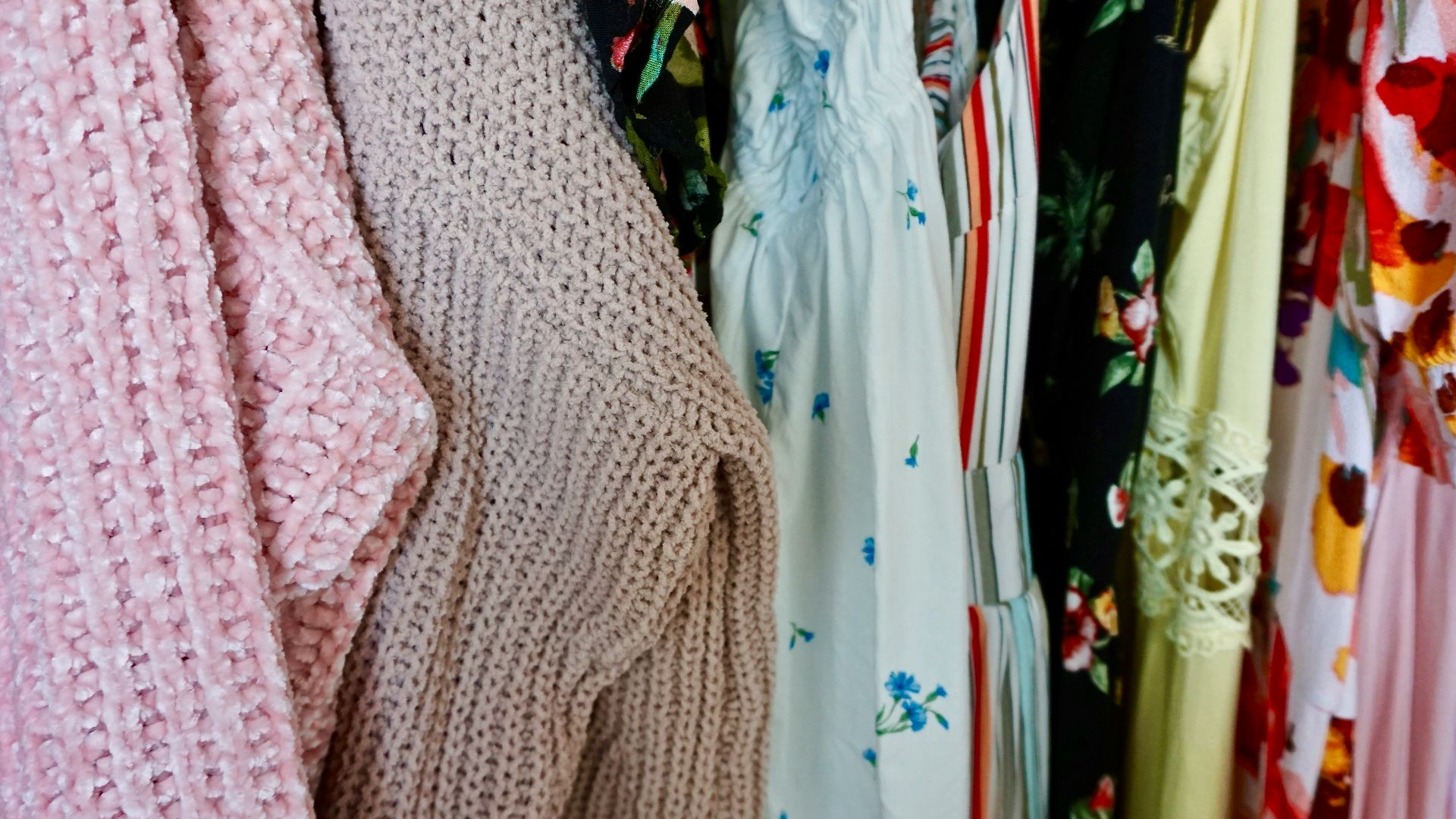 pink knit sweater beside white and blue floral dress