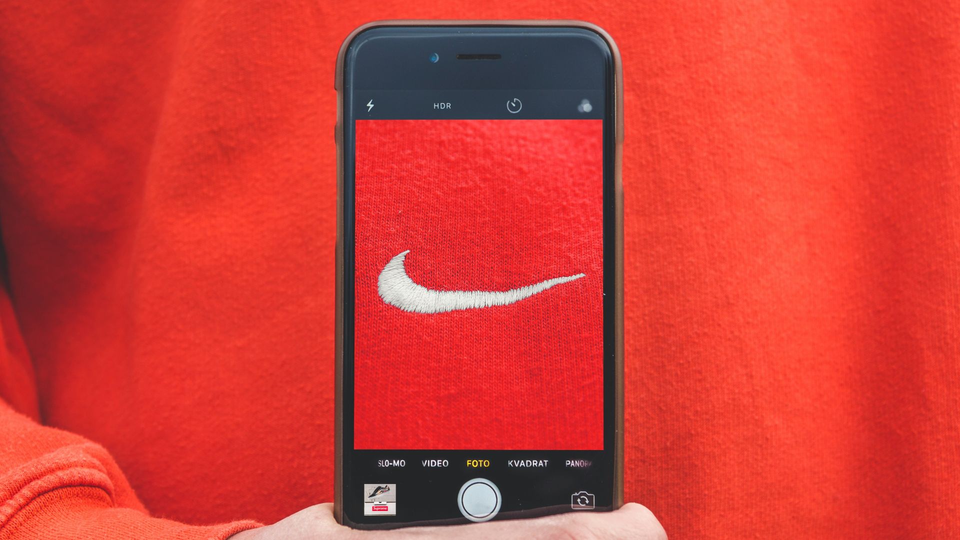 person holding iPhone taking picture on Nike label