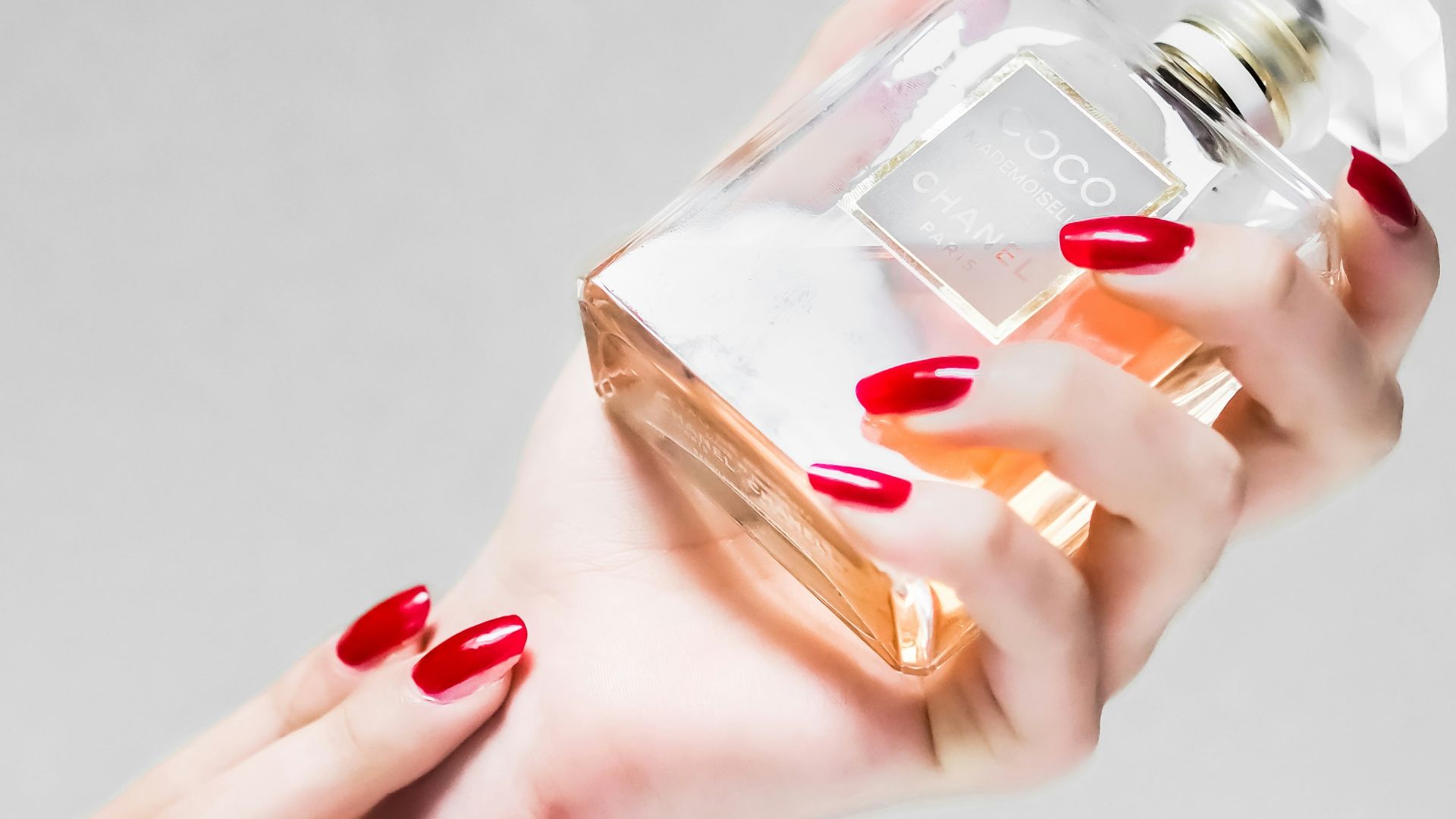 person holding clear glass bottle